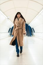 Posing of a brunette girl entering the subway with a jacket in winter