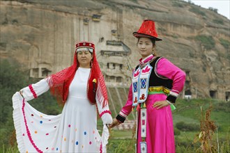 Chinese visitors pose in borrowed traditional costumes at the rock caves of Mati Monastery