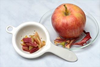 Apple peel tea in tea strainer and apple