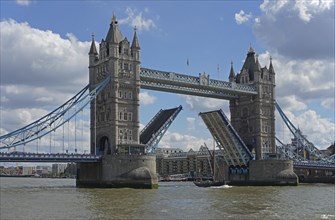 Tower Bridge with raised roadway and sailing ship passing through