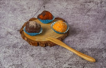 Truffles of different flavors on a wooden disk