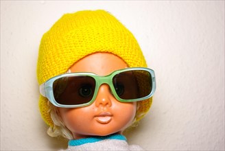 Cool doll with sunglasses and yellow knitted cap