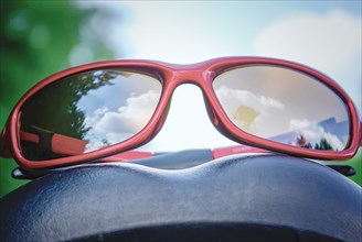 A pair of stylish red sunglasses on a bicycle saddle