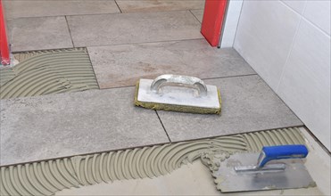 Tiler lays tiles on the floor