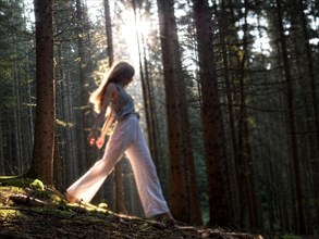 Young woman girl lady in the forest with backlight sunrays