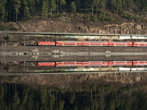 Reflection of a red train on the shore of Schluchsee
