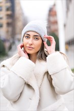 Winter portrait of a caucasian woman in a wool hat in the city