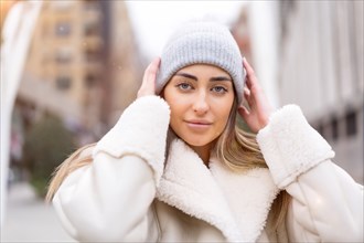 Winter portrait of a caucasian woman in a wool hat in the city