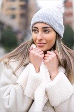 Winter portrait of a caucasian woman with a wool hat in the city