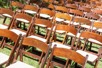Rows of wooden event chairs at wedding venue abstract