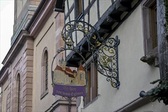 Cast iron sign on a house in Riquewihr