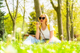A tourist blonde woman sending a voice note with her phone