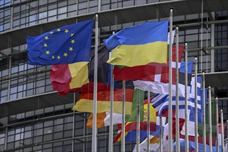Ukrainian and EU flag in the wind in front of the European Parliament