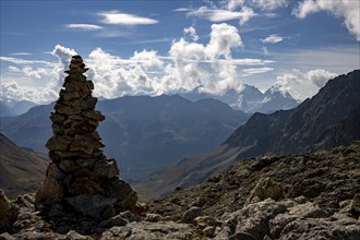 Cairn with Engadine Mountains and Cloudy Sky