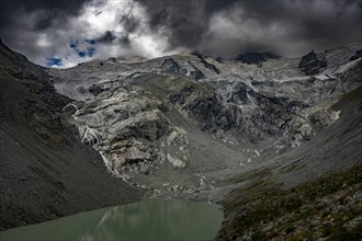 Mountain lake Lej da Vadrett with Rosegg glacier and dramatic clouds
