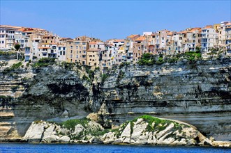 View of cliff from chalk cliffs of Bonifacio with narrow development of old town