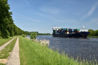 Container ship sailing through the Kiel Canal in spring