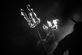 Klausen mask with burning horns and trident in the dark
