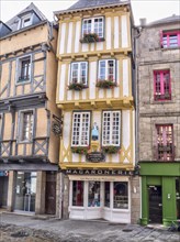 Narrow half-timbered house with statue of a woman in historical traditional costume in the Rue Kereon