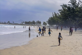 Boys playing soccer on the beach