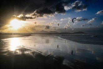 Kitesurfers at sunset on the beach of Caleta de Famara