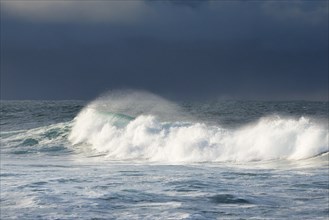 Wave breaking on open water of the North Sea against atmospheric sky
