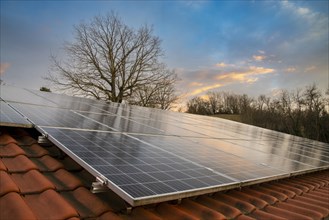 Photovoltaic system on tiled roof in evening light