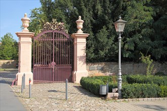 Entrance and portal gate with lidded vases and metal grille to the castle
