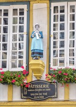 Detail of the half-timbered house with statue of a woman in historical traditional costume in the Rue Kereon