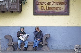 Old men reading newspaper on a bench