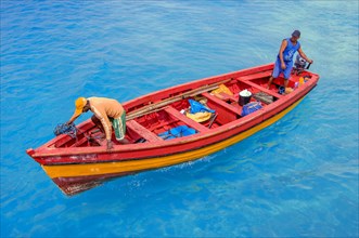 Coloured fishing boat enters harbour lagoon