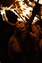Klausen mask with burning horns and trident in the dark
