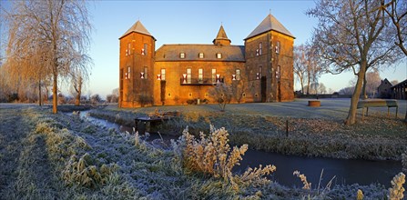Water castle Haus Zelem with hoarfrost at sunrise