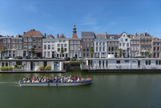 Tour boat in front of historic house facades and houseboats at Londensekaai