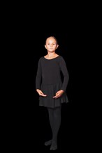 Young girl in dancewear stands in position