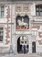 Equestrian statue of Louis XII above the entrance to the Chateau Royal de Blois and a carriage with two white horses