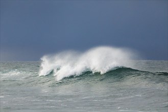 Big wave breaking in the open sea and dramatic light off the north coast of Ireland