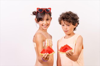 Caucasian children eating a watermelon in the summer heat