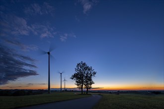 Three wind turbines with road at blue hour
