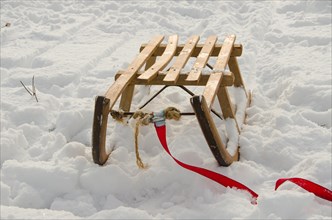Wooden sledge stands in deep snow