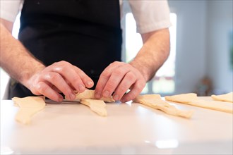 Hands of a man baking croissants