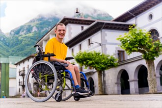 Portrait of a disabled person in a wheelchair walking through the town square