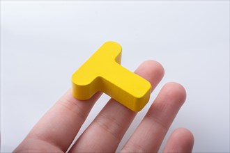 Hand holding letter cube T of made of wood