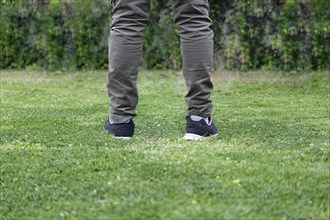 Man legs walking over green grass