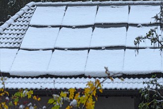 Snow-covered photovoltaic panels on a garage roof