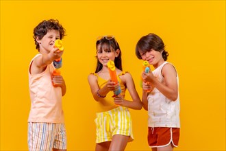 Kids having fun with water guns on summer vacation