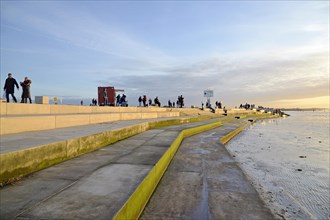 New beach promenade of Norddeich with steps down to the mudflats in the evening light