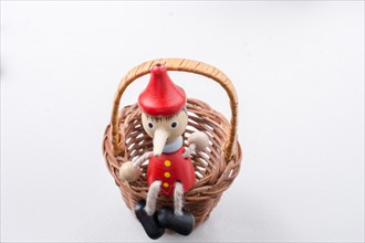 Pinochio toy figurine sitting in a straw basket