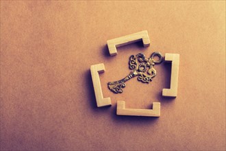 Retro style key in wooden brackets on wooden background