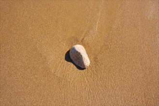 Stone lying in the sand on a beach